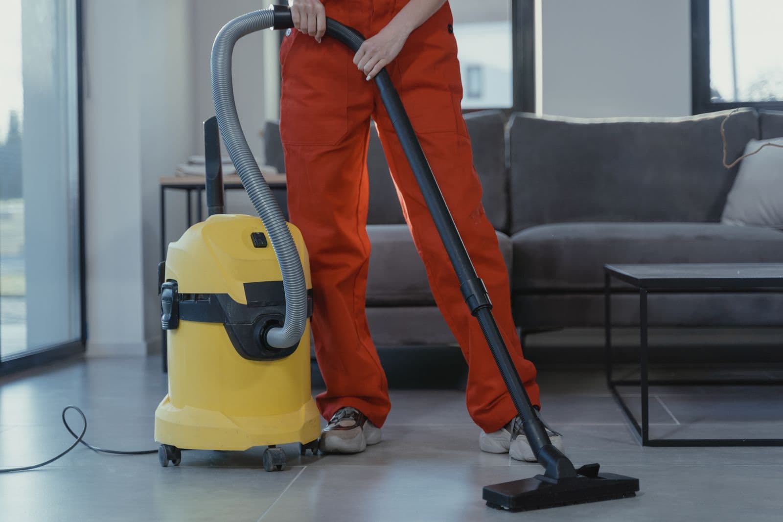 Intervenant professionnel passant l'aspirateur dans un séjour